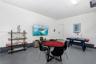 Finished garage space featuring epoxy-coated flooring, neutral wall finishes, and an integrated ceiling-mounted light fixture