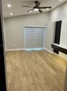 Wood-finish flooring, vaulted ceilings, recessed lighting, ceiling fan with integrated lighting, and a built-in media console featuring vertical accen