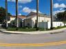 Single-story residence featuring a tile roof, stucco exterior, corner lot positioning, and white privacy fencing