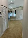 Open-concept space featuring vaulted ceilings, recessed lighting, a stone-veneer accent wall, tile flooring, and built-in cabinetry