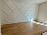 Accent wall featuring geometric millwork and wood-finish flooring
