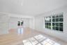 Light-filled interior featuring wood-finish flooring, recessed lighting, a stone-textured accent wall, multi-pane windows, and glass-paned double door