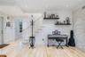 Light wood-finish flooring, textured stone accent wall, recessed lighting, and a staircase with a wooden handrail and balusters
