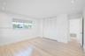 Neutral-toned interior featuring wood-finish flooring, recessed lighting, white louvered closet doors, and a window with a roller shade