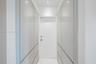 Floor-to-ceiling high-gloss cabinetry with integrated hardware, recessed ceiling lighting, and stone-finish flooring