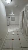 Ceramic tile flooring with accent inlays, flush-mount ceiling lighting, and built-in closet with six-panel doors