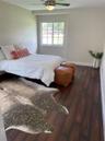 Wood-finish flooring, neutral wall tones, multi-pane window, and a ceiling-mounted light fixture with a fan