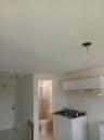 White cabinetry featuring shaker-style doors, integrated range hood, tile flooring, and standard-height plumbing fixtures