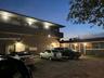 Multi-story exterior structure featuring stucco siding, integrated exterior lighting, and designated paved parking area
