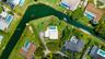 Waterfront parcel featuring a concrete swimming pool, expansive lawn, and direct canal frontage