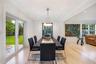 Dining area featuring light-toned wood-finish flooring, recessed lighting, a modern multi-light chandelier, and double glass-paneled doors providing e
