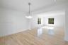 Bright interior featuring wood-finish flooring, multi-pane windows, a contemporary multi-globe pendant light fixture, and recessed lighting