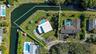 Corner lot property featuring expansive grounds, a swimming pool with a patio surround, and direct water frontage