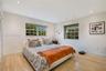 Neutral-toned room featuring light wood-finish flooring, recessed lighting, and dual grid-pattern windows