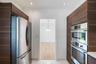 Kitchen featuring full-height wood-finish cabinetry, stainless steel French-door refrigerator, built-in stainless steel double wall ovens, and recesse