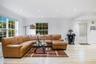Living area featuring light-toned wood-finish flooring, recessed lighting, multi-pane windows, and a glass-paneled entry door