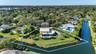Waterfront property featuring a two-story residence, an expansive rear yard, an in-ground swimming pool, and a perimeter fence
