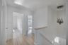 Hallway featuring wood-finish flooring, recessed lighting, a modern multi-pendant light fixture, and a staircase with a wooden handrail