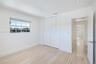 Light-filled room featuring wood-finish flooring, recessed lighting, double louvered closet doors, and multi-pane window