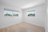 Interior space featuring wood-finish flooring, recessed lighting, multi-pane windows with fitted shades, and louvered closet doors