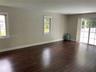 Interior space featuring wood-finish flooring, recessed lighting, double-hung windows with grid detailing, and glass sliding doors
