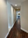 Hallway featuring wood-finish flooring, recessed lighting, and neutral wall paint