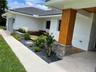Exterior facade featuring a concrete tile roof, stone masonry accents, a wood-finish support column, and built-in wood decking with integrated bench s