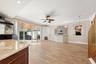 Wood-finish tile flooring, sliding glass doors, corner built-in shelving, custom cabinetry with a stone-finish accent wall, and recessed lighting