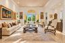 Expansive living area featuring high ceilings with recessed lighting, oversized crown molding, polished stone tile flooring, and glass-paned double do