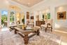 Living space featuring high ceilings, recessed lighting, tile flooring, an arched transom window, and multi-panel glass doors