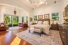Tray ceiling with recessed lighting, wood-finish flooring, and large sliding glass doors providing outdoor access