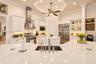 Gourmet kitchen featuring a large central island with a quartz countertop, stainless steel appliances, white cabinetry with glass-front display sectio