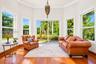 Sunroom featuring wood-finish flooring, a decorative pendant light, and multiple oversized windows providing natural illumination