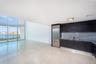 Kitchen featuring dark cabinetry, integrated stainless steel refrigerator, stone-style backsplash, and light-toned flooring, with floor-to-ceiling win
