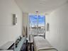 Floor-to-ceiling windows, dark wood-finish flooring, built-in cabinetry with a glass surface, recessed ceiling lighting, and wall-mounted sconce light