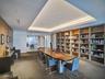 Recessed tray ceiling, floor-to-ceiling built-in wood shelving, and integrated linear lighting