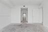 Neutral-toned interior space featuring crisp white walls, a solid-core interior door, and a pass-through doorway