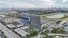 High-rise residential tower featuring a glass facade, expansive coastal horizon, and proximity to an equestrian track