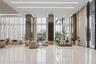 Lobby featuring floor-to-ceiling windows, polished stone flooring, recessed linear lighting, and reflective structural columns