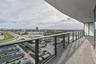 Covered balcony featuring concrete flooring and a sleek metal railing with glass panels