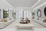 Expansive room featuring soaring ceilings with recessed cove lighting, floor-to-ceiling windows, and polished stone flooring