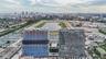 Aerial perspective featuring high-rise concrete structures positioned along a large oval racetrack and central water basin