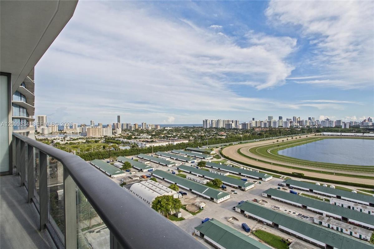 Private balcony featuring a glass panel railing and metal handrail