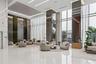 Grand lobby featuring floor-to-ceiling windows, high-gloss stone flooring, mirrored structural pillars, integrated recessed ceiling lighting, and a ve