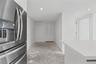 Stainless steel French-door refrigerator, crisp white cabinetry, quartz-style countertop, and double-panel louvered closet doors