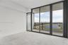 Floor-to-ceiling glass sliding doors opening to a private balcony with metal railings and expansive outdoor scenery