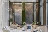 Double-height lobby featuring floor-to-ceiling stone wall panels, a vertical moss installation, metallic wall accents, and an extensive suspended pend