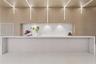 Custom kitchen island featuring a waterfall stone countertop, integrated vertical linear LED lighting, wood-paneled feature wall, and stone slab backs