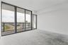 Floor-to-ceiling glass paneling featuring dark metal framing, exterior balcony access, and expansive panoramic outdoor scenery