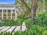Bright sun room spills to landscaped yard with turf and concrete landing paths. House for rent in Coconut Grove.